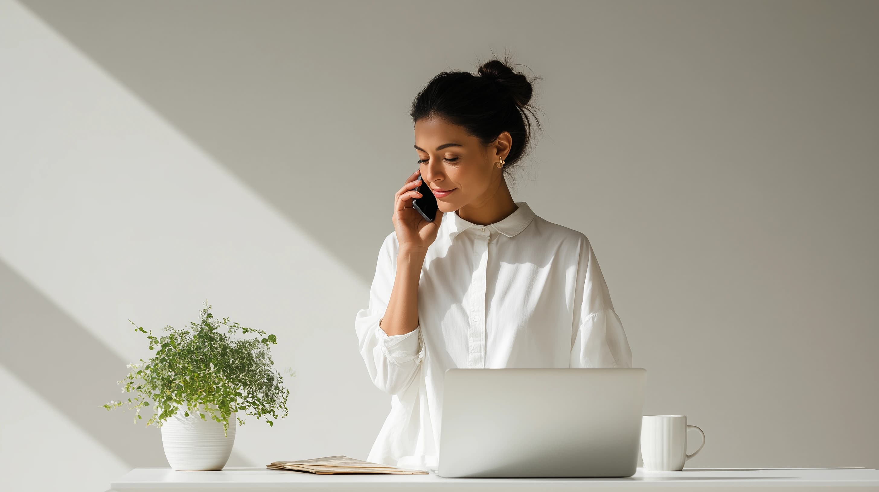 A woman working at here desk on the phone with website studio